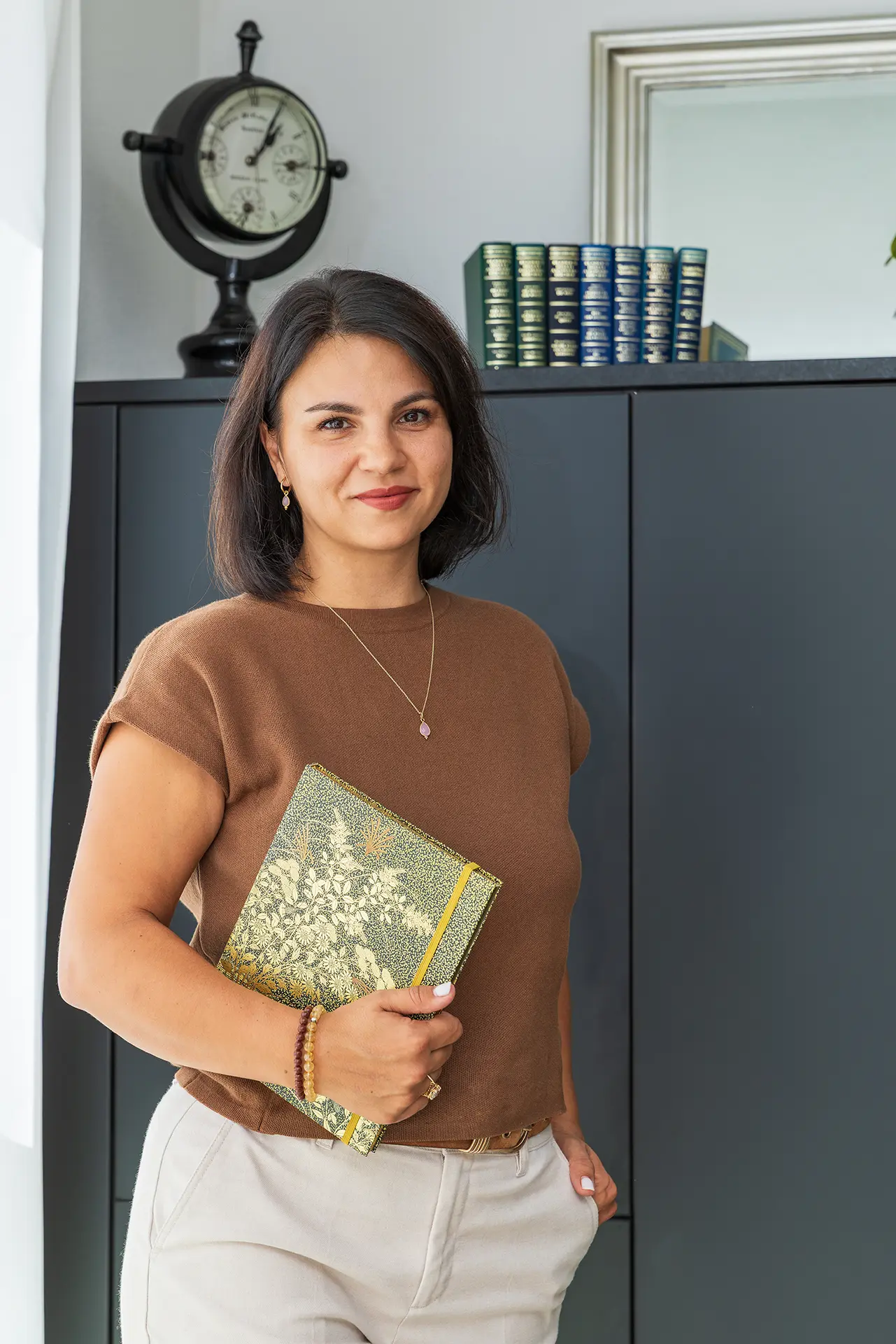 Juanita Keitel, ThetaHealing® Instructor, mit Handbuch vor dem Bücherschrank