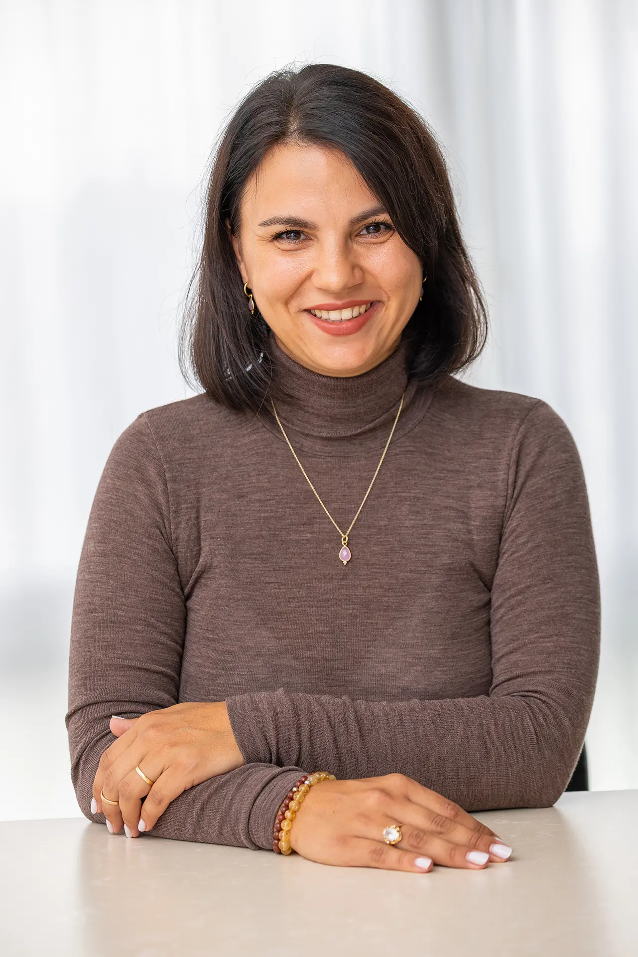 Juanita Keitel, ThetaHealing® Instructor aus Pliezhausen, sitzt am Schreibtisch und lächelt in die Kamera