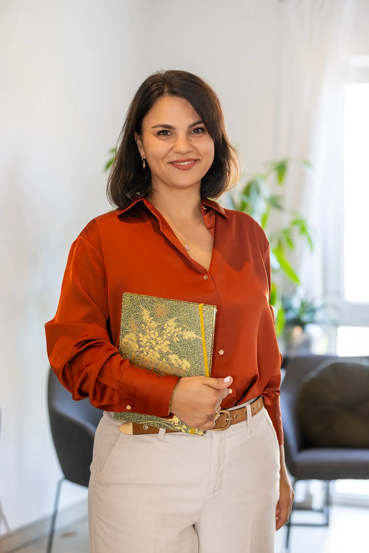 Juanita Keitel steht mit dem ThetaHealing® Handbuch in der Hand